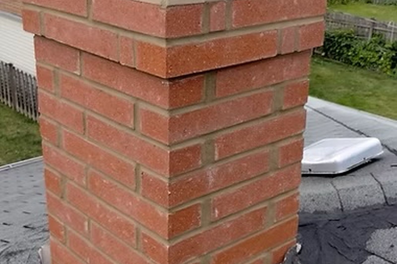 Red brick chimney with new flashing and chimney cap on a New Jersey roof