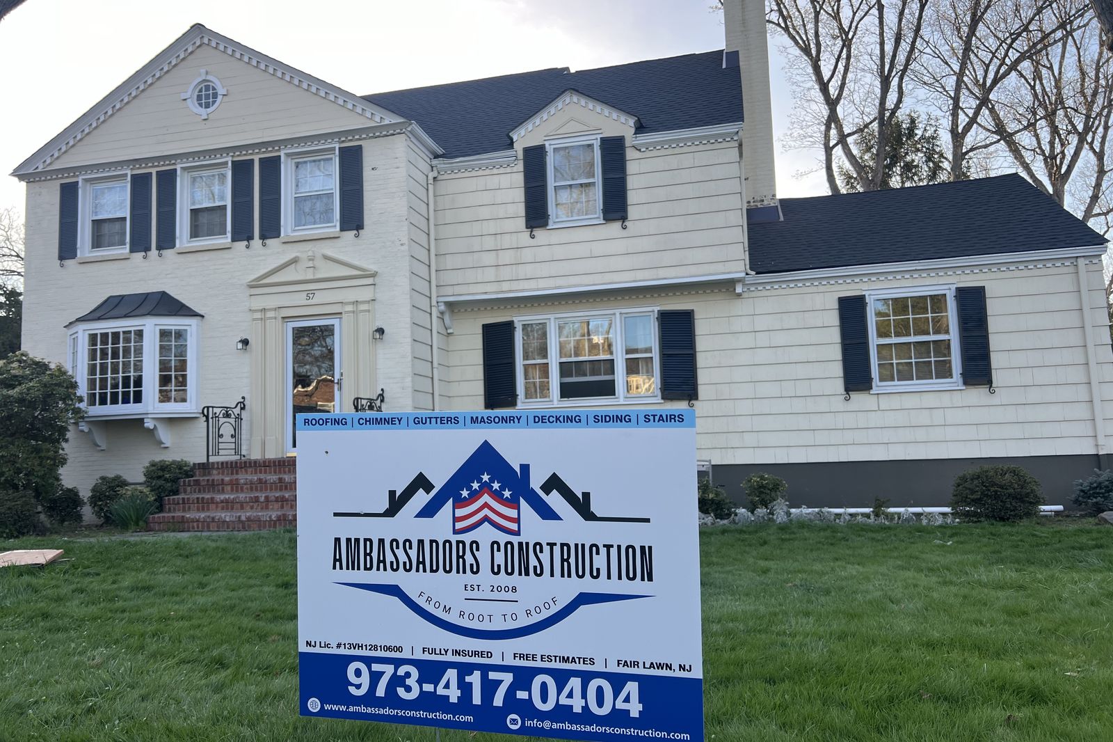 New Jersey home with a newly replaced roof and Ambassadors Construction yard sign