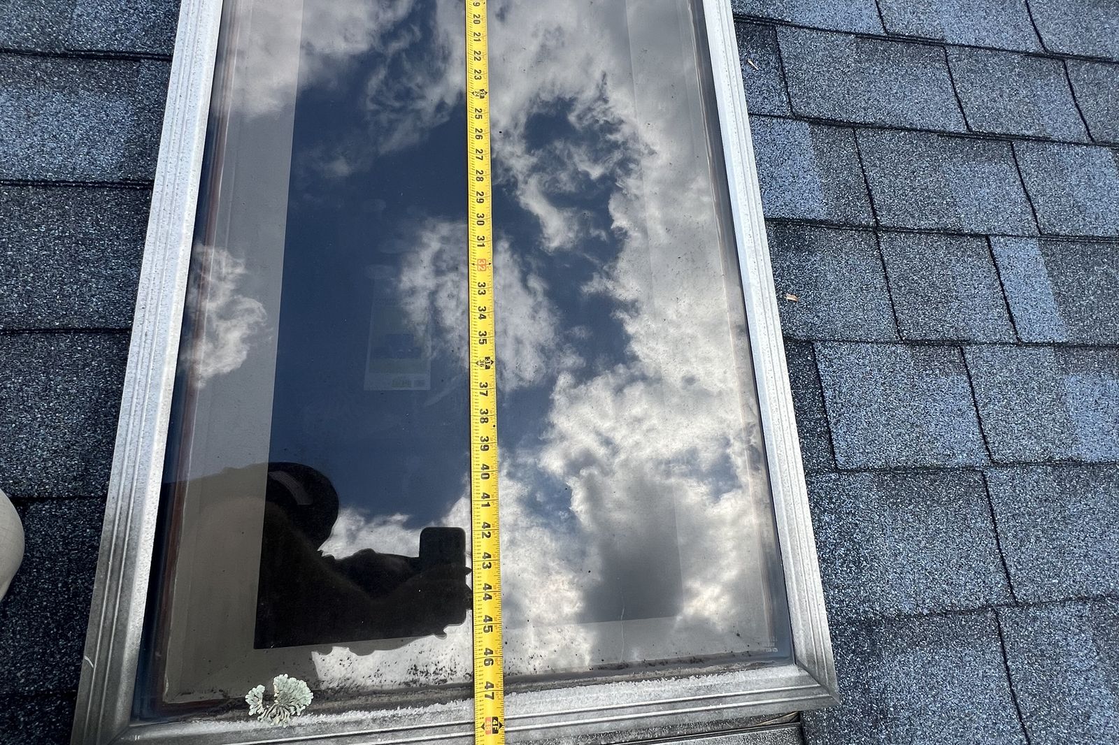 Close-up of an old skylight being measured before repair or replacement in New Jersey