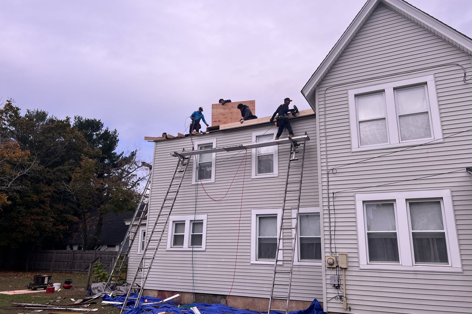 Ambassadors Construction crew installing new plywood decking during a roof installation in New Jersey