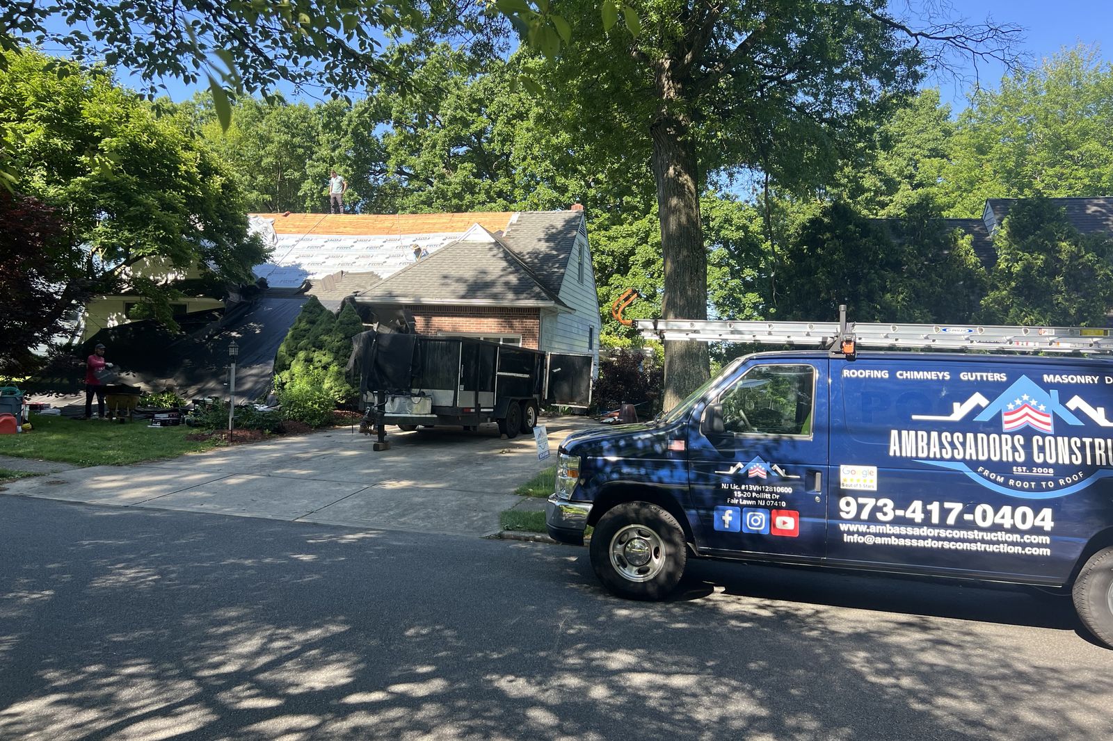 Ambassadors Construction van parked at a New Jersey home during roof installation with underlayment visible