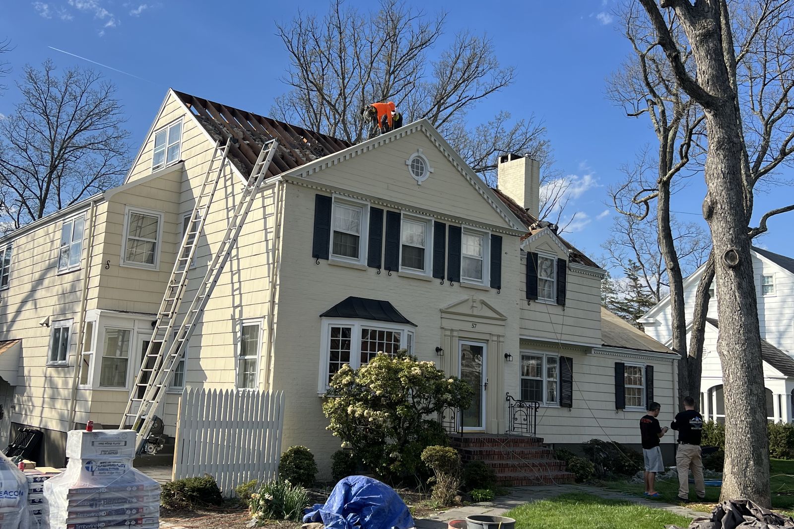 Roofing materials staged in the driveway during a full roof replacement in New Jersey