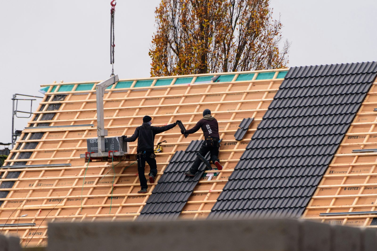 Roofing contractors installing new asphalt shingles on a New Jersey home