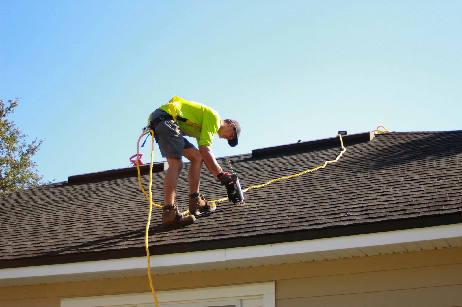Roofer nailing new asphalt shingles into place during a roof installation in New Jersey