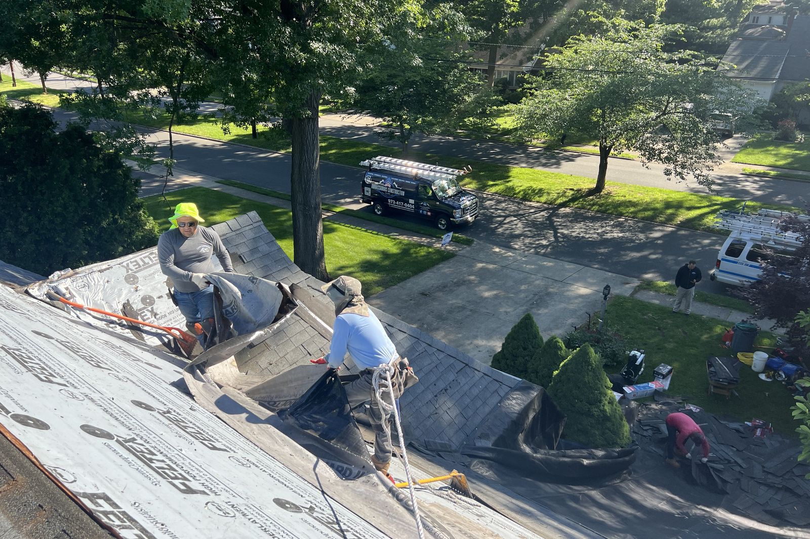 Ambassadors Construction crew removing old shingles during a roof replacement in New Jersey