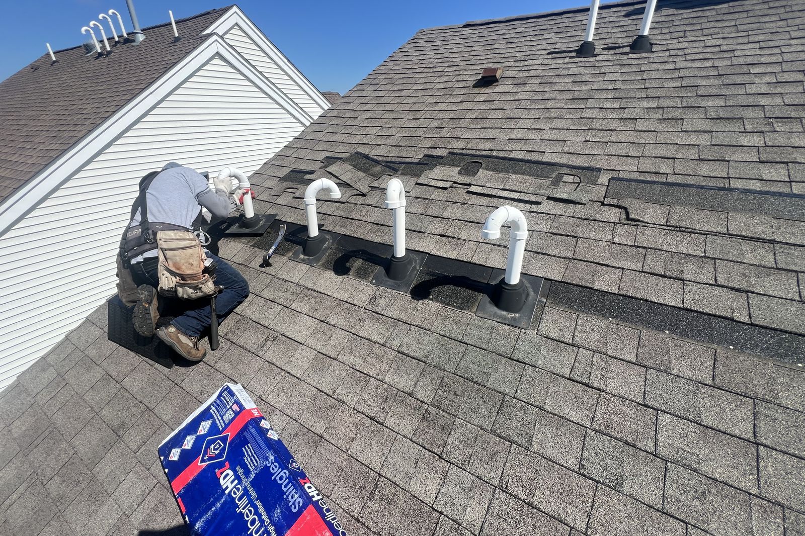 Ambassadors Construction roofer installing pipe boot flashing during a roof installation in New Jersey