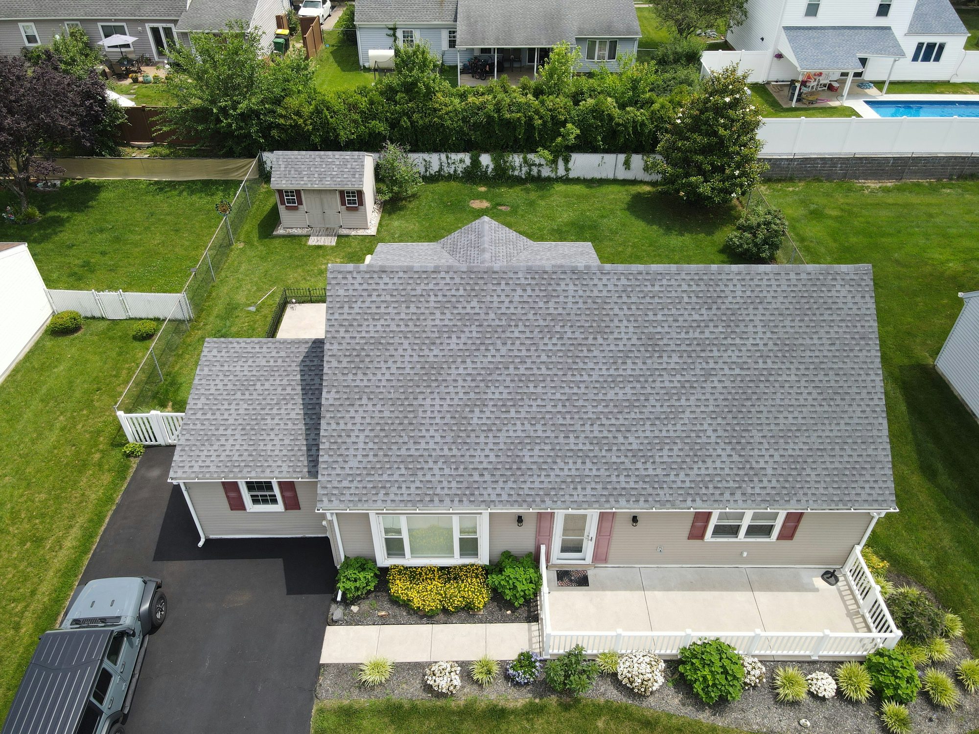 Aerial view of a completed asphalt shingle roof installed by Ambassadors Construction in New Jersey
